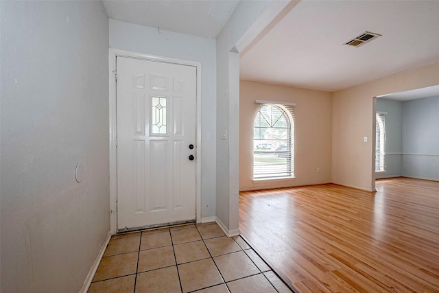 entryway featuring baseboards, light wood-type flooring, and visible vents