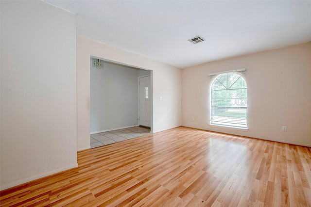 spare room with baseboards, visible vents, and light wood finished floors
