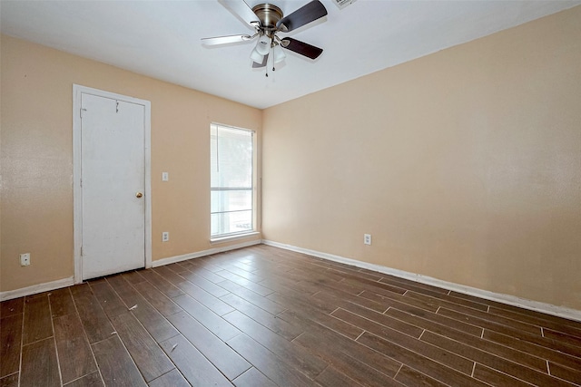 spare room featuring a ceiling fan, baseboards, dark wood finished floors, and visible vents