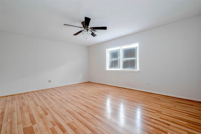 unfurnished room with baseboards, a ceiling fan, and light wood-style flooring