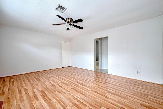 spare room with light wood-style floors, baseboards, a ceiling fan, and visible vents