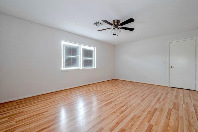empty room with visible vents, light wood finished floors, ceiling fan, and baseboards