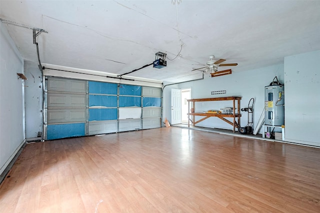 garage featuring a garage door opener, a ceiling fan, and electric water heater