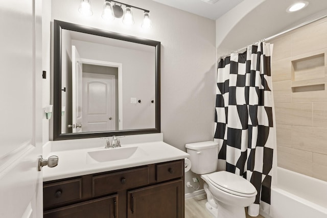 full bath featuring toilet, shower / bath combo with shower curtain, and vanity