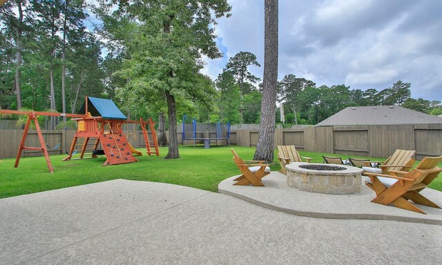 view of patio / terrace with a playground, a trampoline, a fire pit, and a fenced backyard