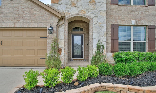 doorway to property with a garage and stone siding