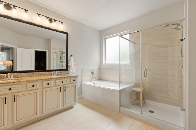 bathroom featuring a sink, a shower stall, a garden tub, and a healthy amount of sunlight