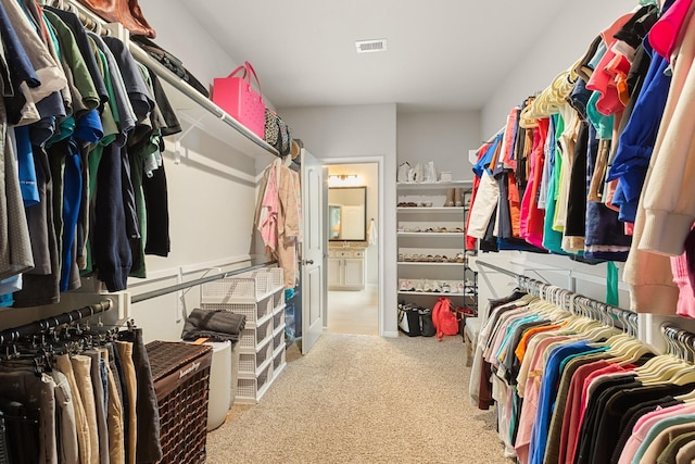 walk in closet with visible vents and carpet