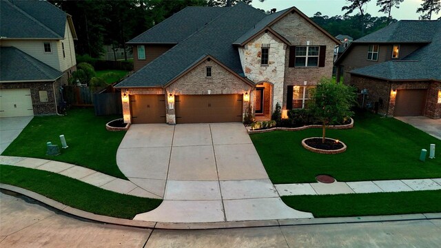 view of front of home featuring an attached garage, stone siding, a front yard, and concrete driveway