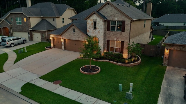 traditional home with a garage, fence, concrete driveway, and a front yard