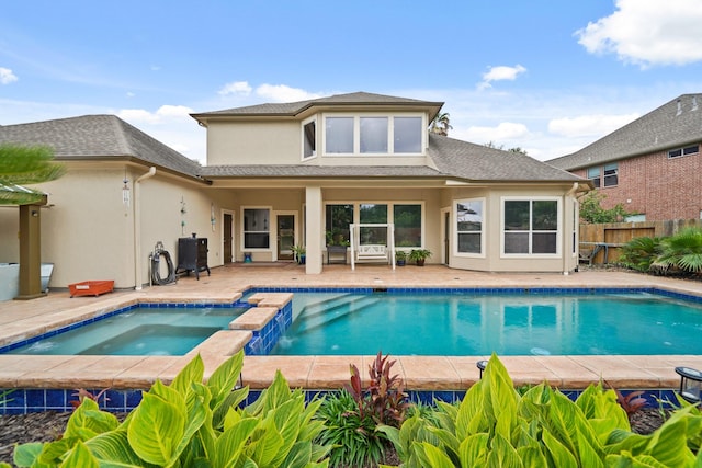 back of property with fence, a patio, stucco siding, a shingled roof, and a pool with connected hot tub
