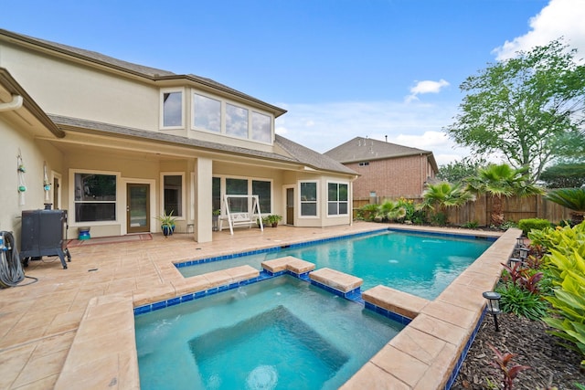 view of pool with a pool with connected hot tub, a fenced backyard, and a patio area