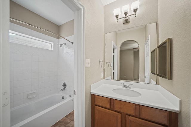 bathroom with shower / bath combination, a textured wall, tile patterned floors, and vanity