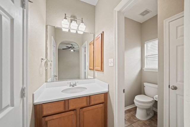 bathroom with ceiling fan, visible vents, vanity, tile patterned floors, and toilet