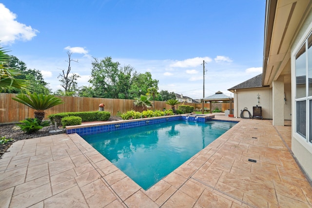 view of swimming pool featuring a fenced backyard, a patio area, and a pool with connected hot tub
