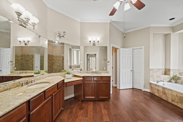 bathroom with a ceiling fan, a tile shower, a sink, and wood finished floors