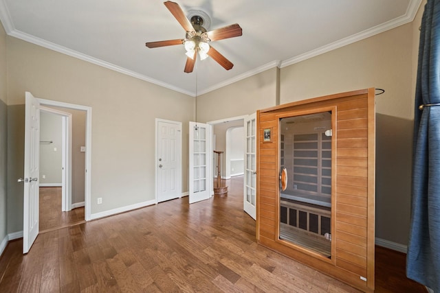 interior space with a ceiling fan, french doors, crown molding, wood finished floors, and baseboards