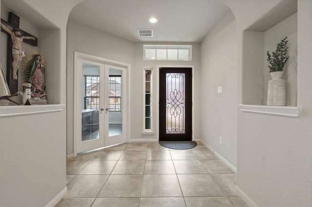 tiled foyer featuring arched walkways, french doors, recessed lighting, baseboards, and visible vents