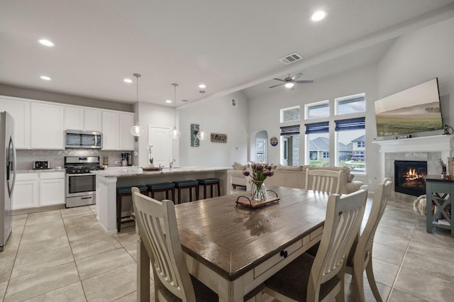 dining space with visible vents, light tile patterned flooring, recessed lighting, a tiled fireplace, and a ceiling fan