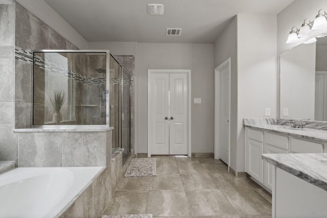 bathroom with visible vents, a bath, a stall shower, and vanity