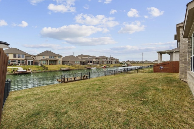 view of yard with a residential view, a water view, and a fenced backyard
