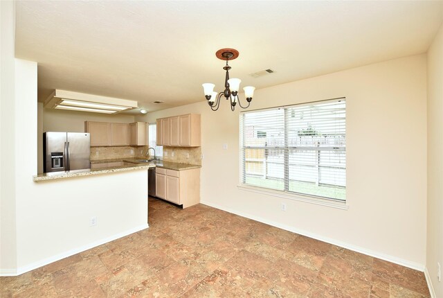 kitchen with visible vents, decorative backsplash, an inviting chandelier, baseboards, and stainless steel fridge