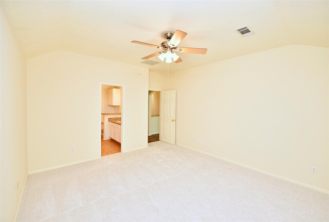 spare room featuring a ceiling fan, visible vents, light carpet, and lofted ceiling