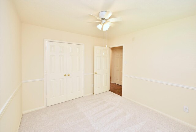 unfurnished bedroom featuring carpet floors, baseboards, ceiling fan, and a closet