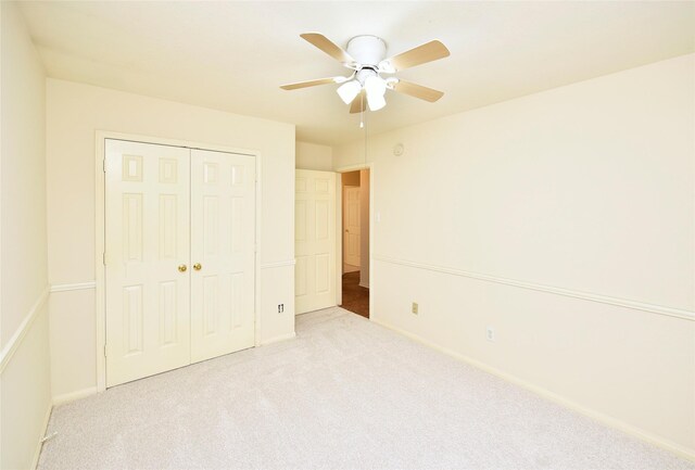 unfurnished bedroom with a ceiling fan, baseboards, carpet, and a closet