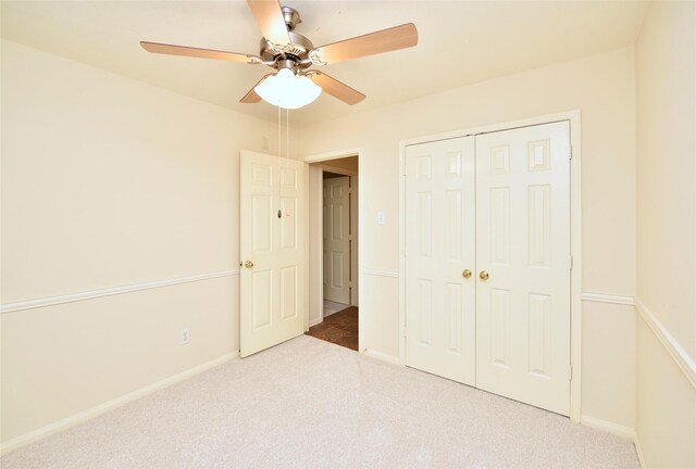 unfurnished bedroom with carpet floors, a ceiling fan, baseboards, and a closet