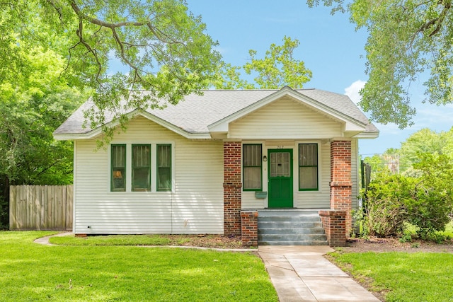 202 10th Ave N, Texas City, TX 77590 - view of front of house featuring brick siding, fence, a shingled roof, and a front yard