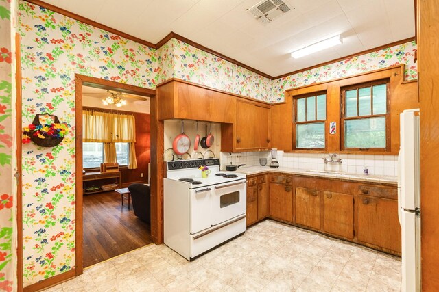 202 10th Ave N, Texas City, TX 77590 - kitchen featuring crown molding, light countertops, brown cabinets, and white appliances