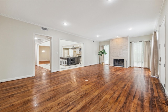 7924 Woodway Dr, Houston, TX 77063 - unfurnished living room with visible vents, crown molding, wood finished floors, a fireplace, and baseboards
