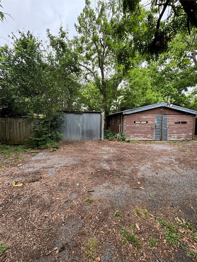view of yard featuring fence and an outbuilding
