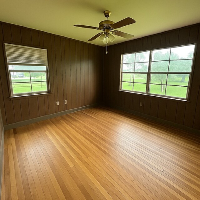 1904 Gun And Rod Rd, Brenham, TX 77833 - spare room featuring light wood-type flooring, a ceiling fan, and wood walls