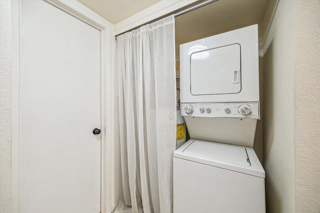 16111 Aspenglenn Dr Unit 404, Houston, TX 77084 - washroom with laundry area, a textured wall, and stacked washer / dryer