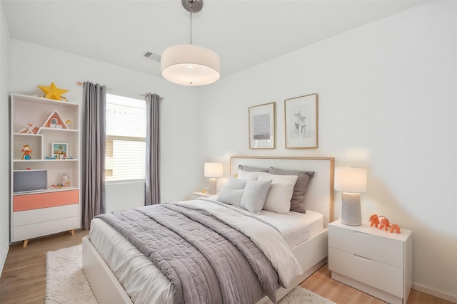 bedroom with light wood-type flooring and visible vents