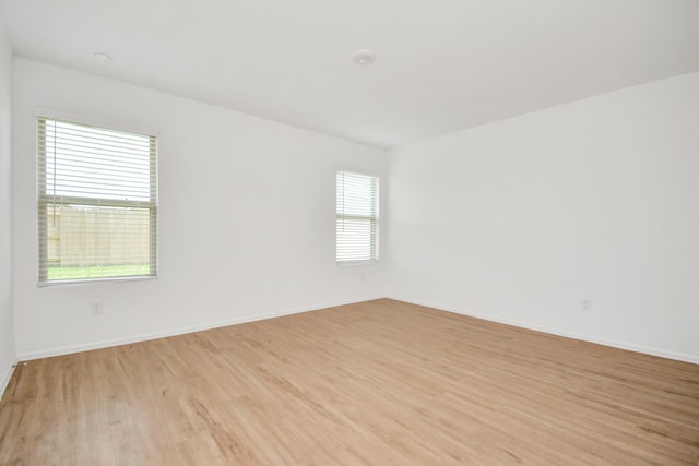 empty room with light wood-style floors and baseboards