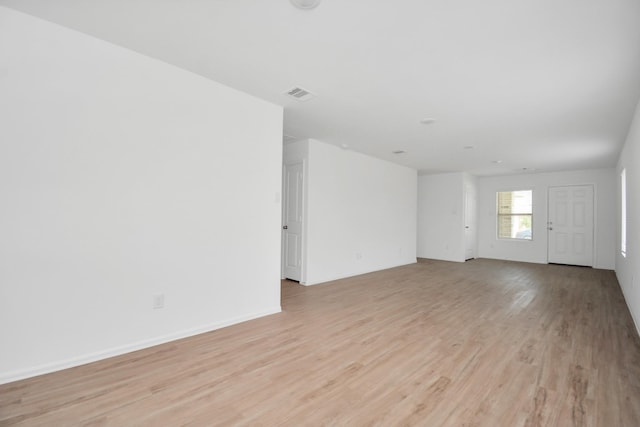 unfurnished room featuring light wood-style floors, baseboards, and visible vents