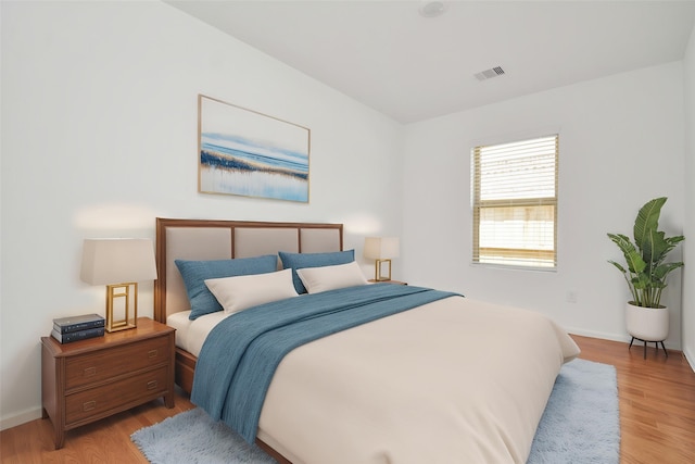 bedroom with light wood-style floors, baseboards, and visible vents