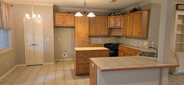 kitchen with black range with gas cooktop, tile countertops, tasteful backsplash, a sink, and a notable chandelier