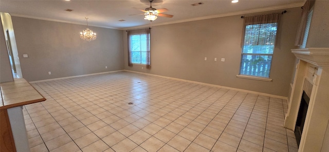 empty room featuring plenty of natural light, crown molding, ceiling fan with notable chandelier, and a fireplace
