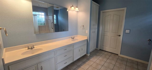 bathroom with a sink, baseboards, tile patterned flooring, and double vanity