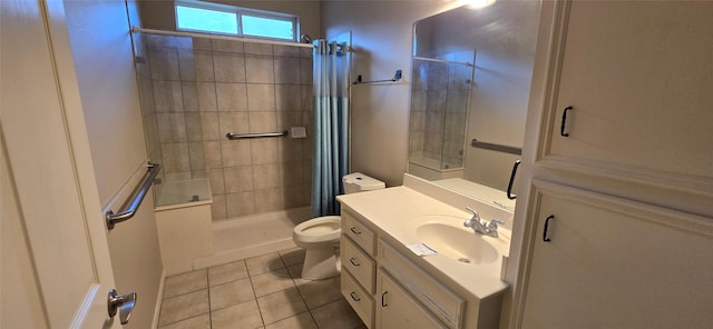 bathroom featuring vanity, tile patterned flooring, a tile shower, and toilet
