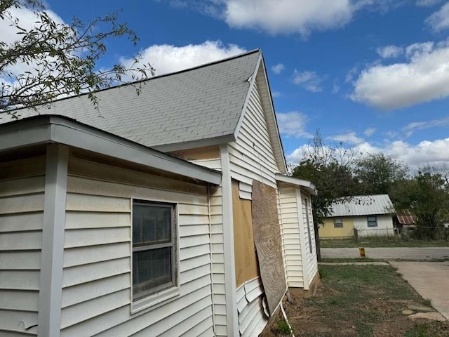 view of side of home with a shingled roof