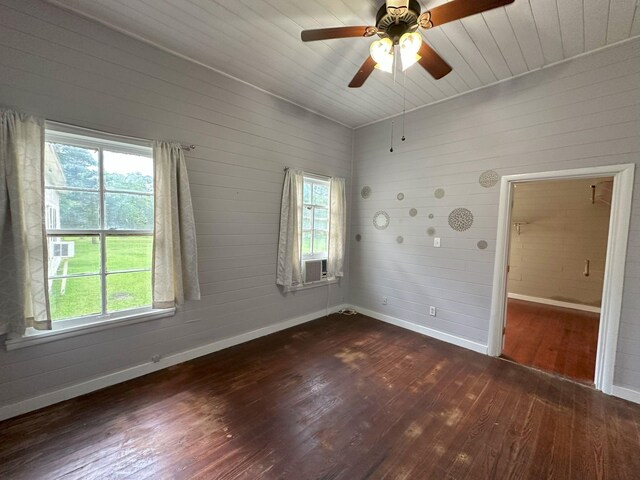 spare room featuring baseboards, plenty of natural light, and dark wood-style floors