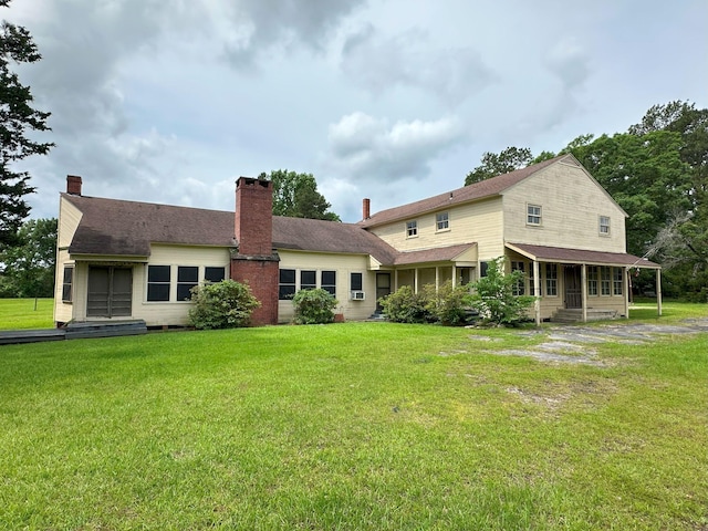 back of house with a lawn and a chimney