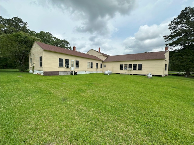 back of house with a lawn, a chimney, and entry steps