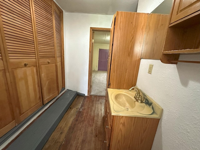 bathroom with vanity, a textured wall, and hardwood / wood-style flooring