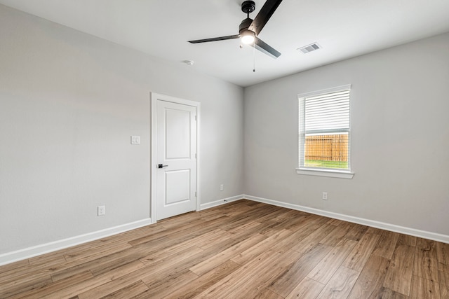 empty room featuring visible vents, light wood finished floors, and baseboards